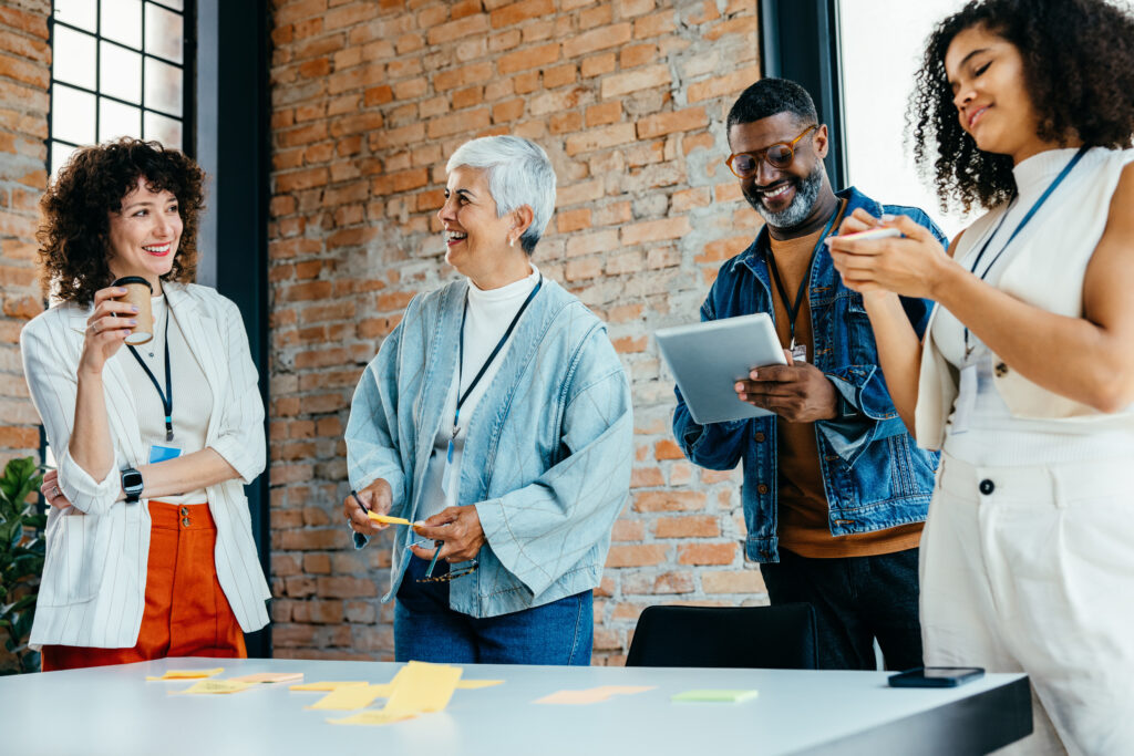 Multiethnic team of professionals engaged in a lively brainstorming session, sharing ideas and laughter in a contemporary office environment.